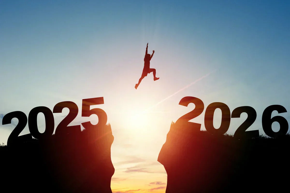 illustration of a man jumping from a 2025 hill to a 2026 hill