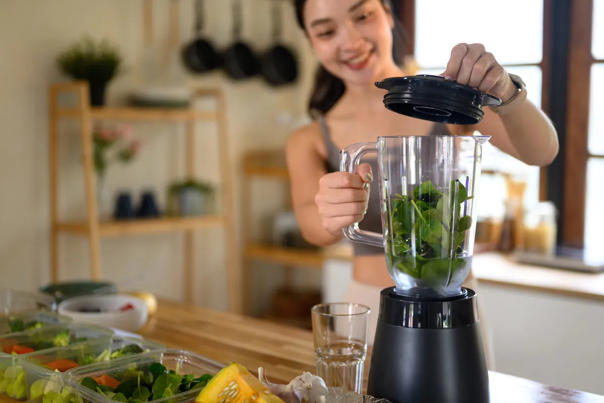  woman preparing food and shake for cleanse after holiday eating