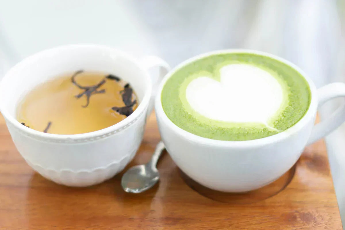 a cup of brewed green tea next to a cup of matcha or green tea latte