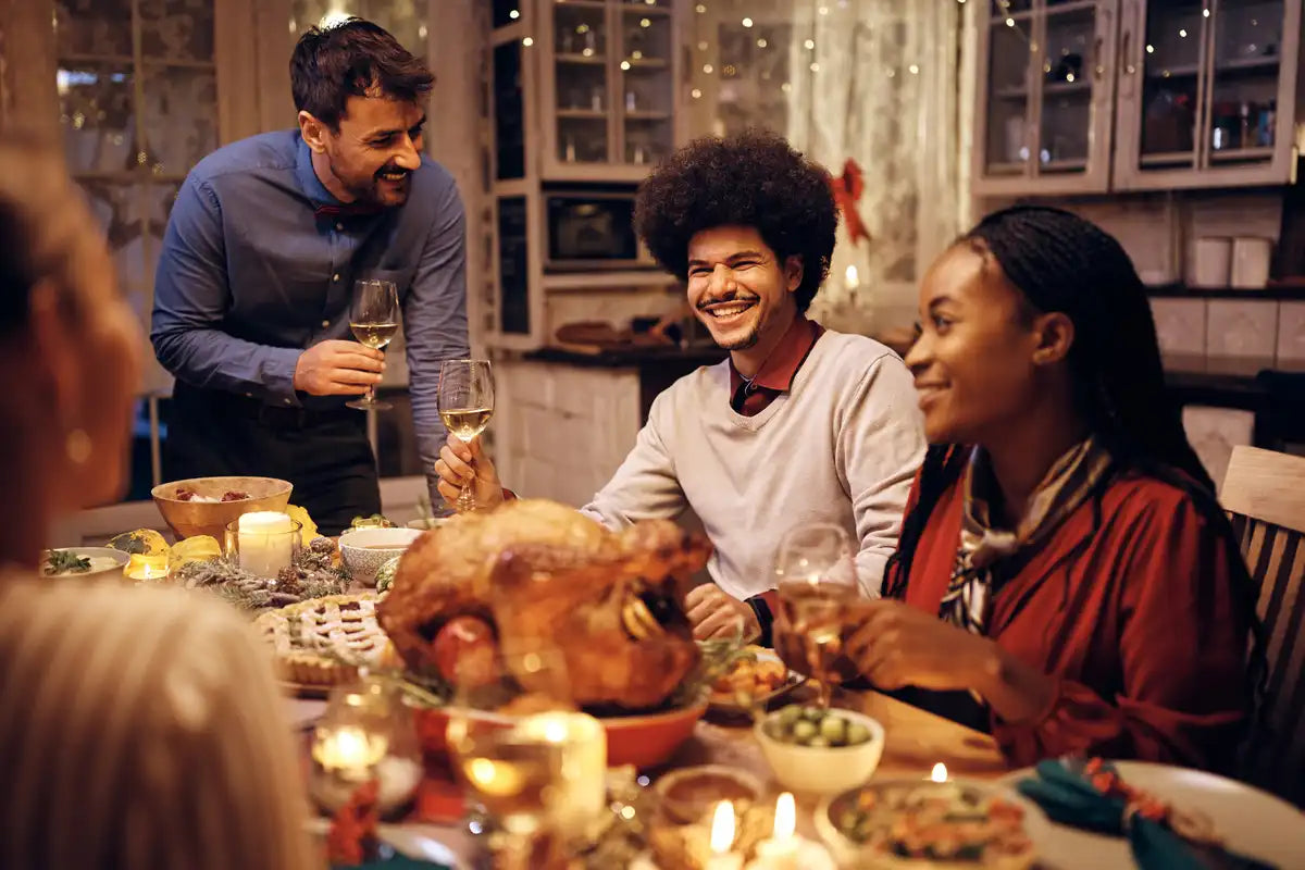 group of friends at the dinner table enjoying eating together