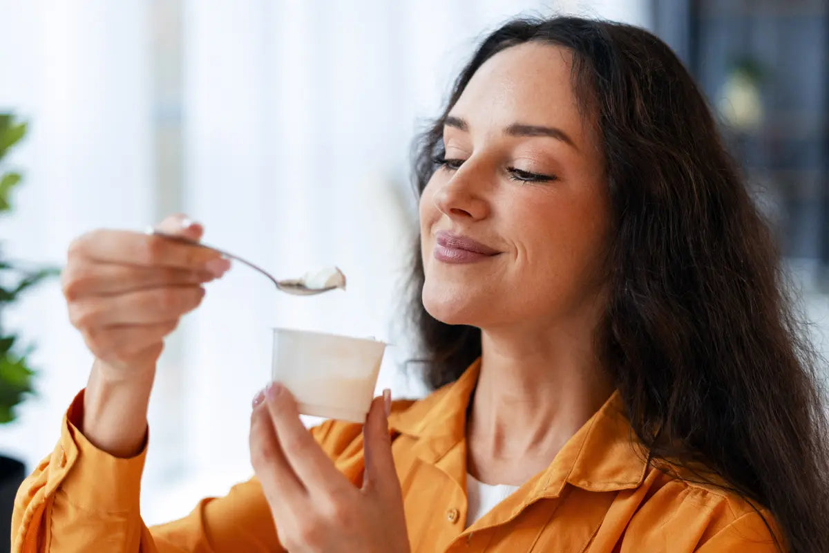 woman eating a yogurt with lactobacillus probiotics
